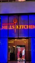 Gordon RamasyÃ¢â¬â¢s HellÃ¢â¬â¢s Kitchen restaurant with red and blue lights at night with people inside in Las Vegas Nevada